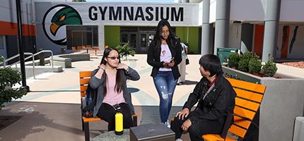 Students sitting in front of the Gym