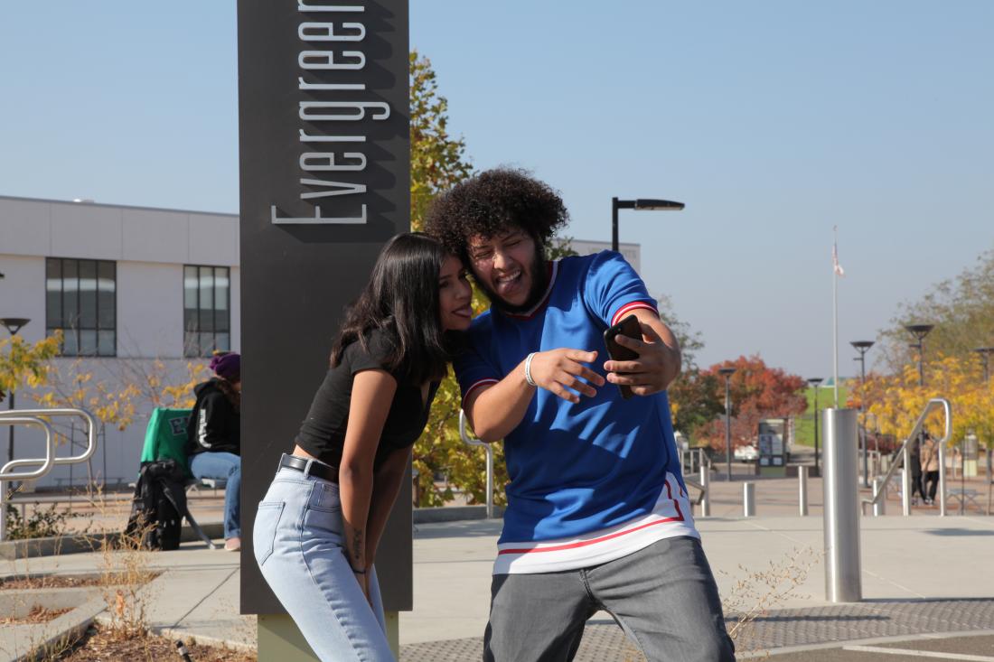 two students looking at their phone