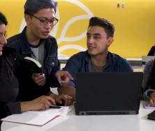 Four students sitting in front of a laptop
