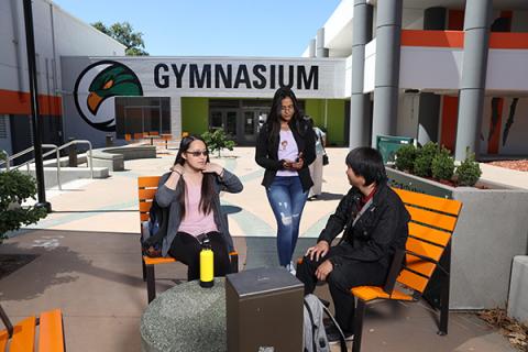 Students sitting in front of the Gym