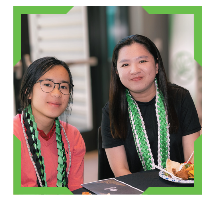 Two students looking into camera and smiling.